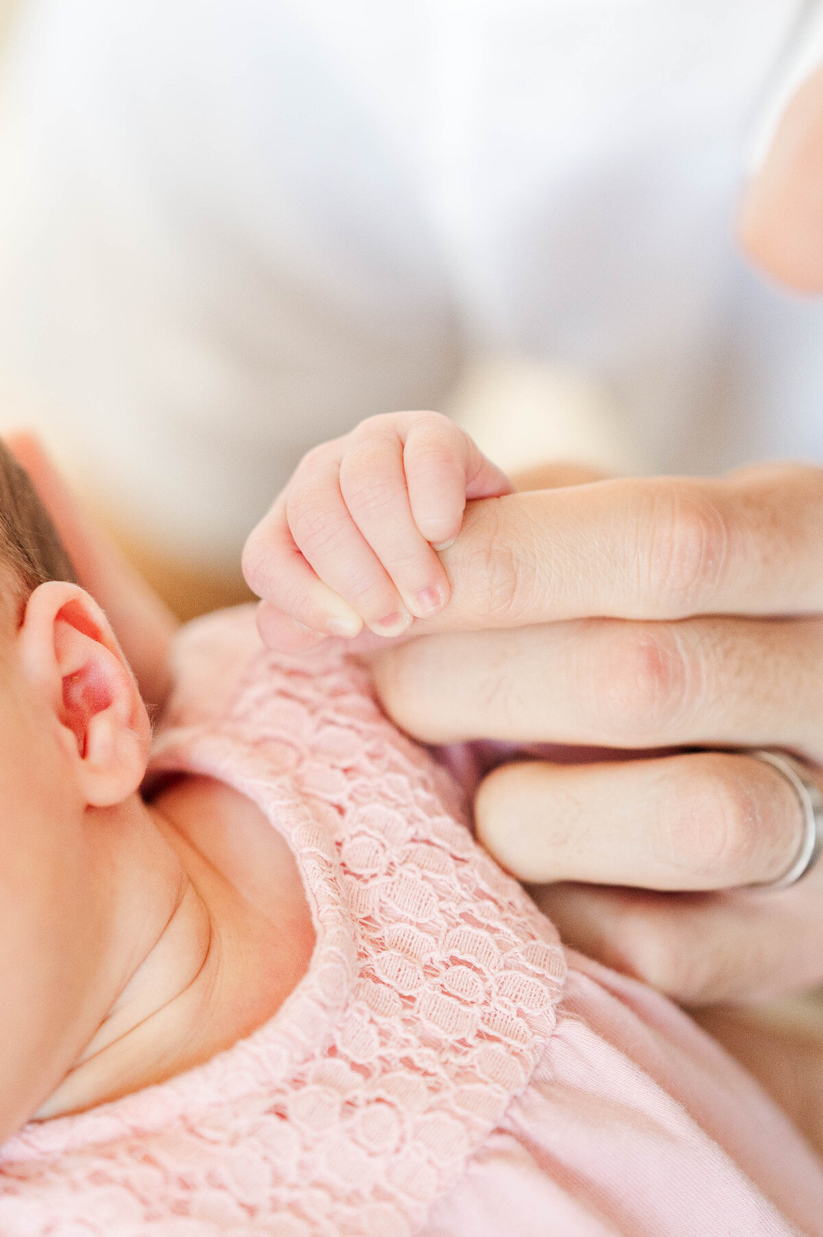newborn girl holding dad's fingers taken in Westwood, MA by best Westwood newborn photographer