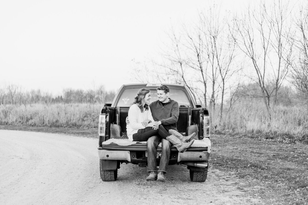 couple sitting in the bed of a truck laughing
