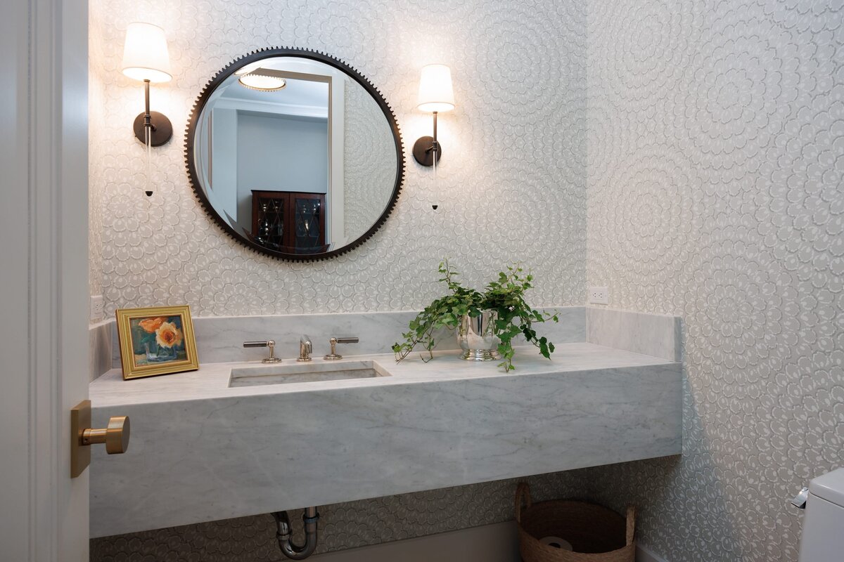 the keeping room interiors primera bathroom with round mirror and gold frame on vanity