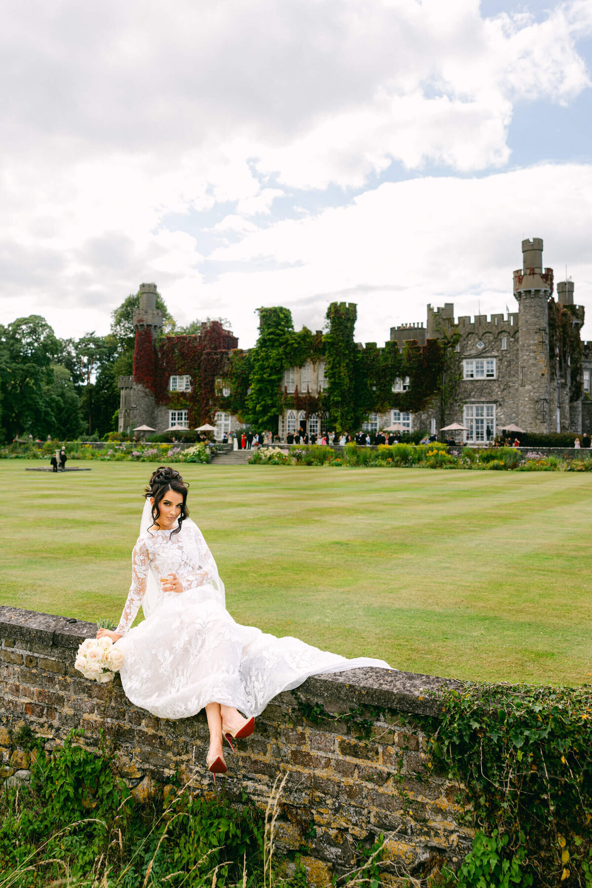A wedding photo of the bride in her white dress with Luttrellstown Castle in the background