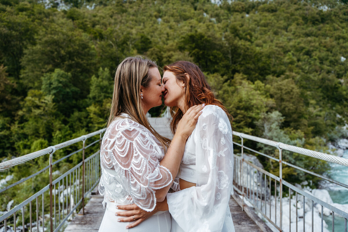 lesbian couples kissing riverside elopement Slovenia