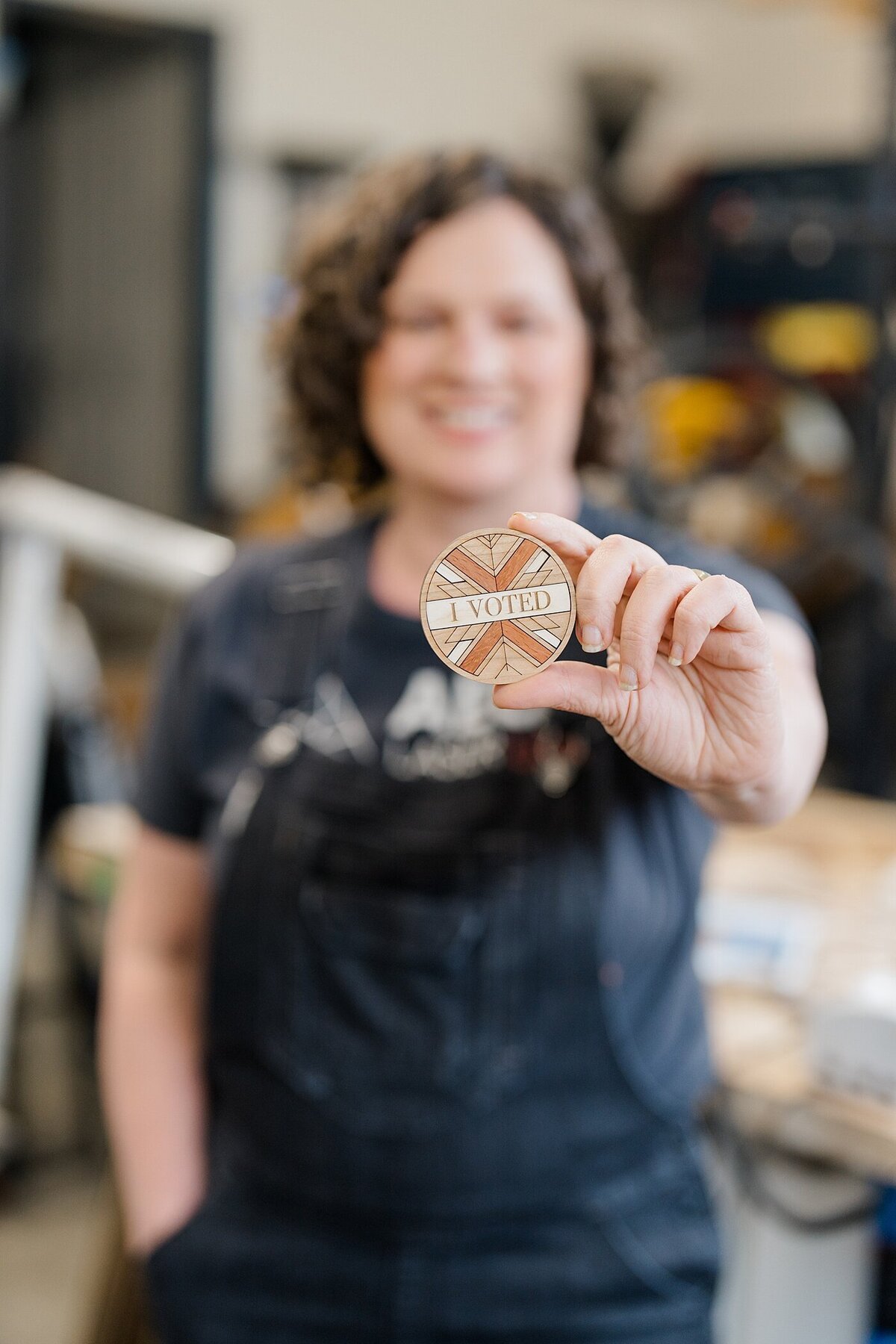 woman holding an I voted pin that is made from wood for personal branding photography