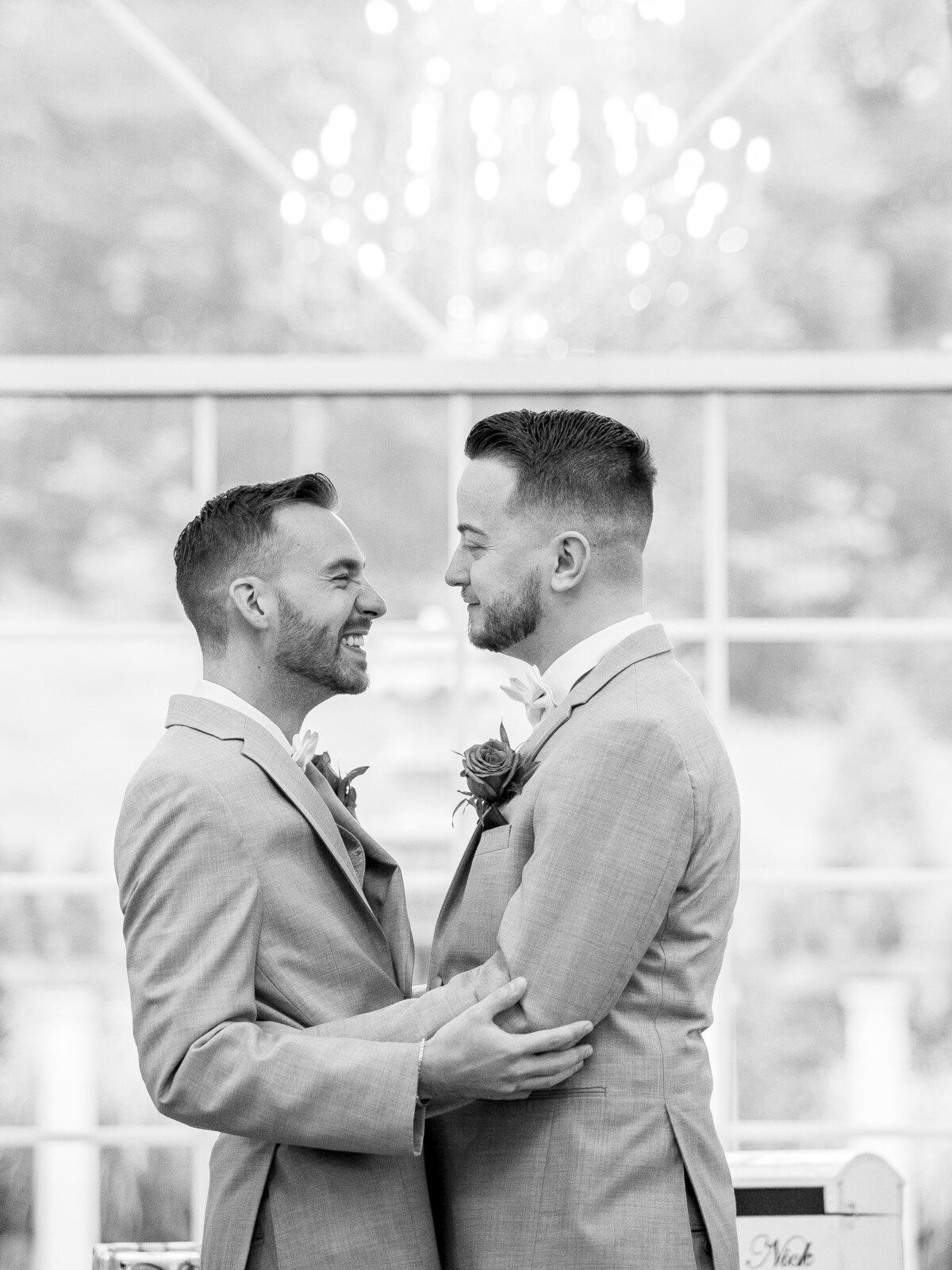 Grooms laugh after their first kiss.
