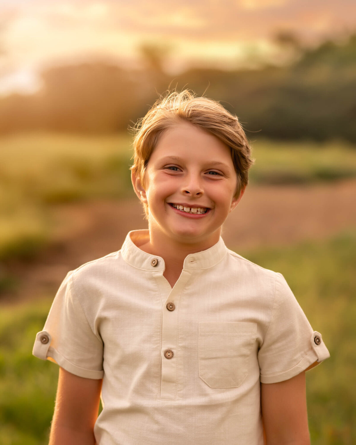 A young boy in a white shirt standing in the grass at Craggy Gardens