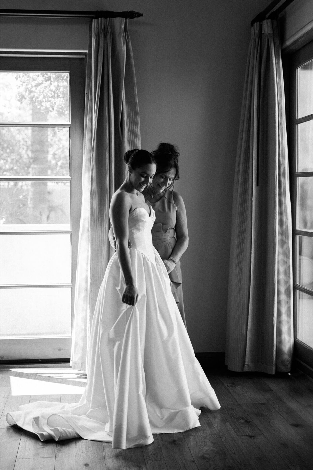 Bride sharing a quiet moment with her mother by the window before the ceremony, captured by a luxury wedding photographer in Arizona.