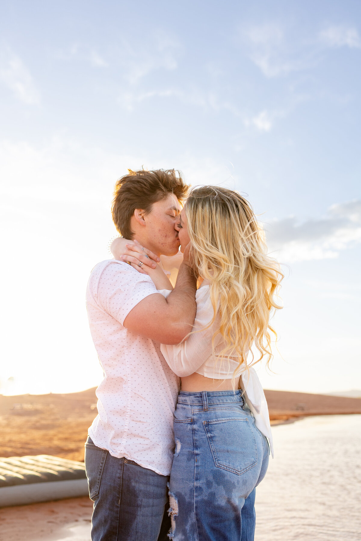 The young man pulls his fiance in for passionate kiss at Sand Hollow Reservoir