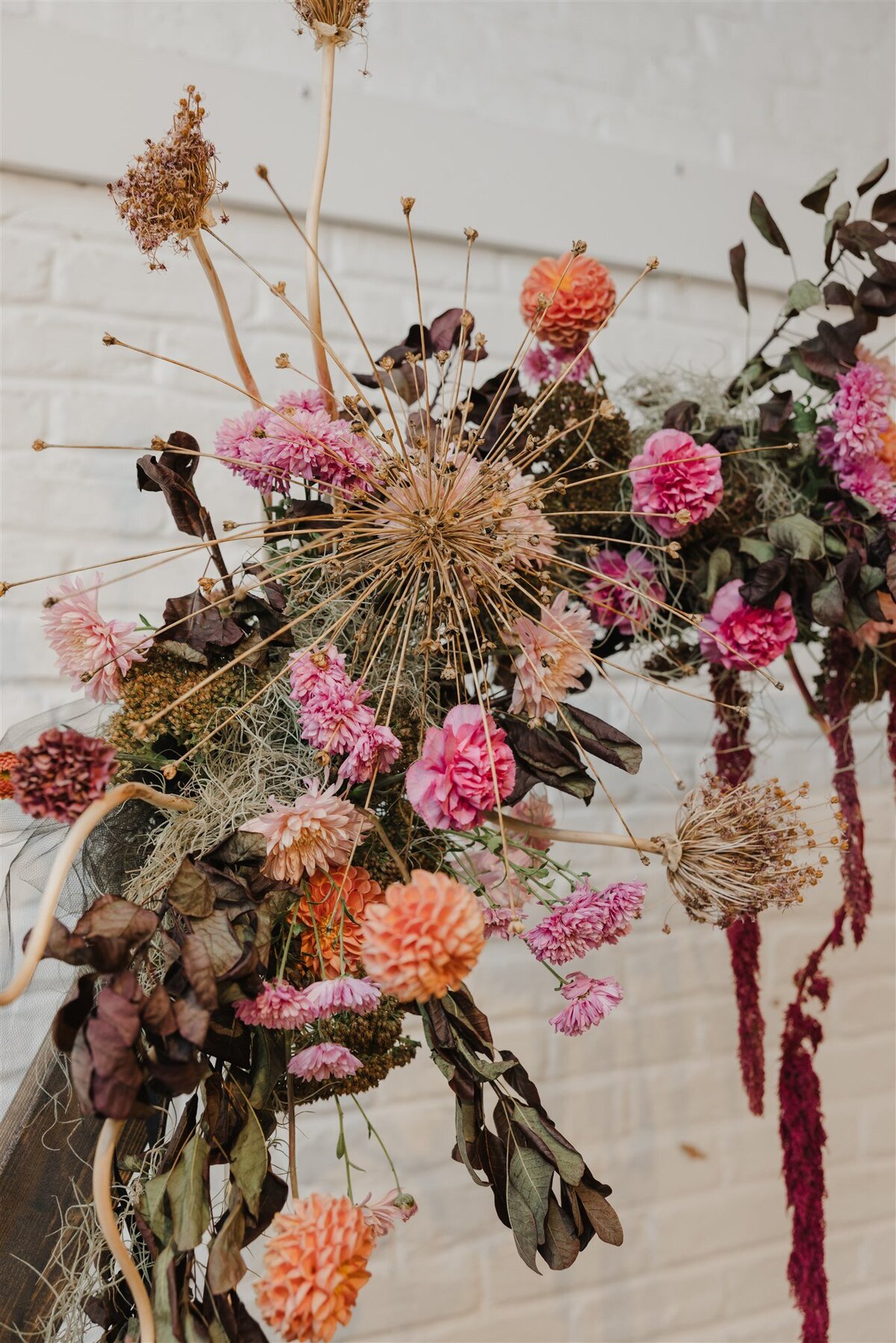 Detail of burgundy, plum and dried flowers on a ceremony arch