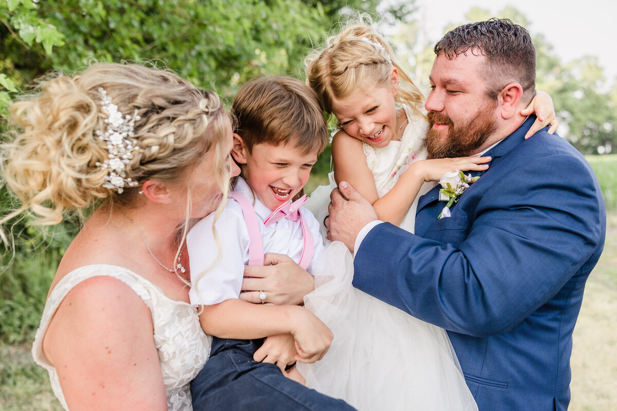 Bride and Groom celebrate their wedding with their son at the barn at Hornbaker Gardens in Princeton, Illinois.