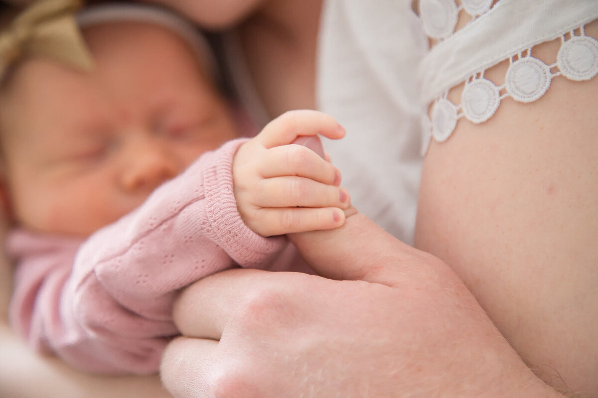 newborn baby girl holding dads thumb