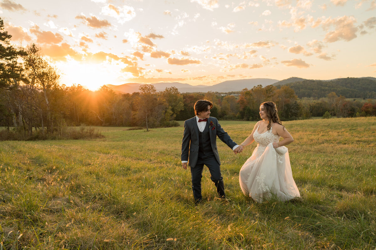 The groom is leading the bride for photos in the mountains of Virginia.