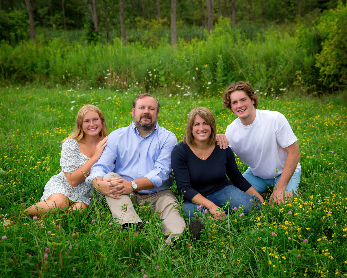 Family portrait taken of a high school senior girl from Victor, NY with her family in a field 