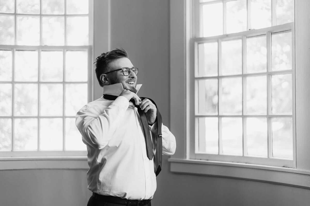 Groom getting dressed into suit
