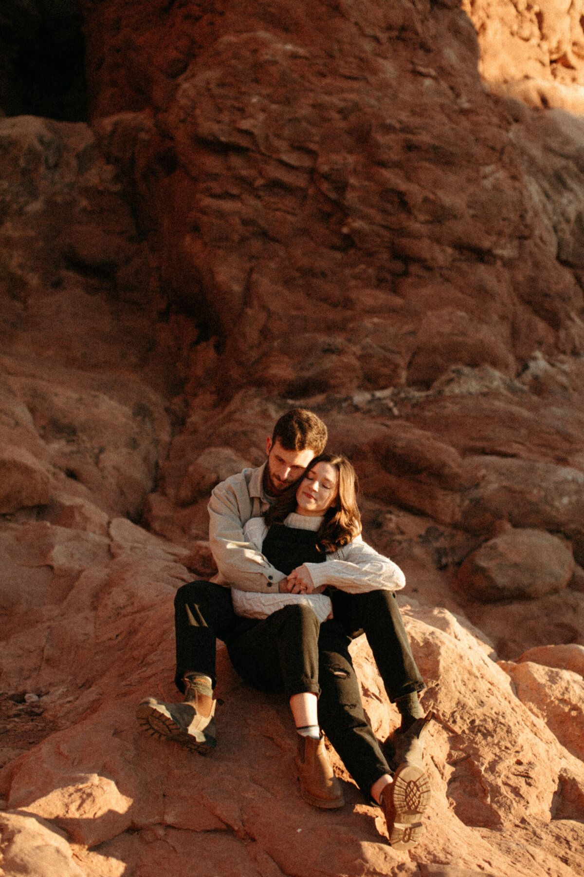Couple snuggling together on a rock in the desert