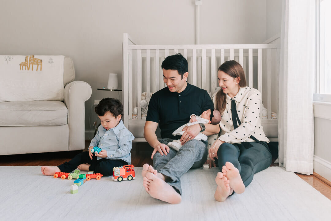 A family of four enjoying time together during their newborn session with Denise Van Photography