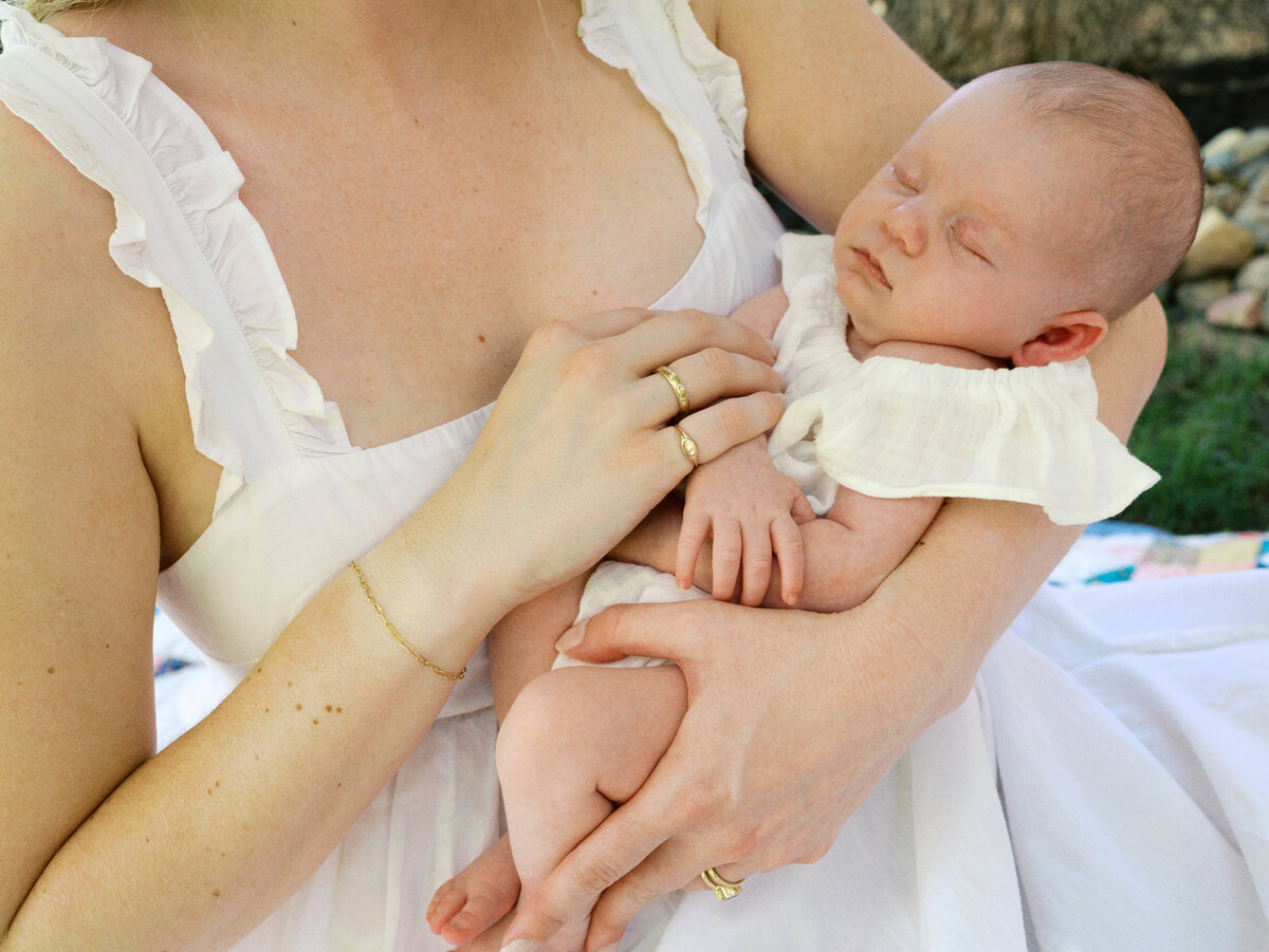 mom-white-dress-holding-sleeping-baby