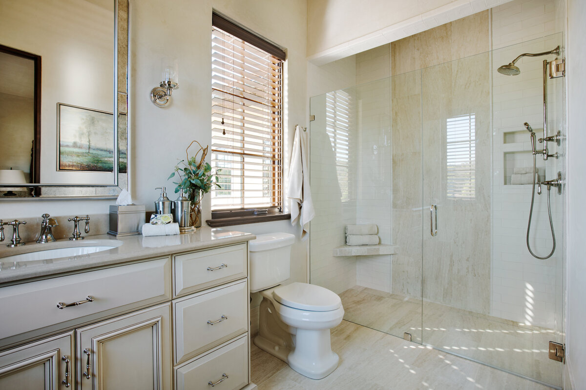 Panageries Residential Interior Design | Italian Country Villa Guest Bath with Handheld, Built In Shelving, and cream, brown, and white hues
