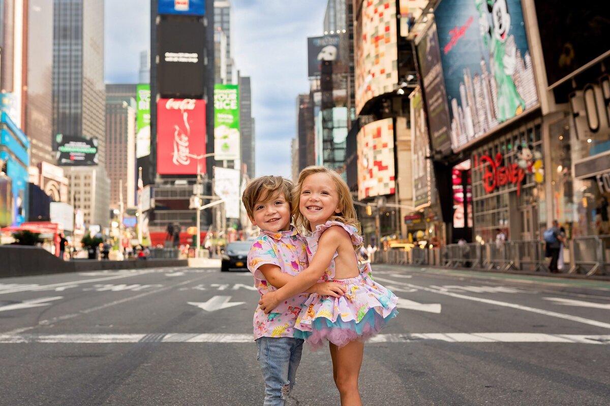 Two siblings hug in front ot Times Square in New York City.