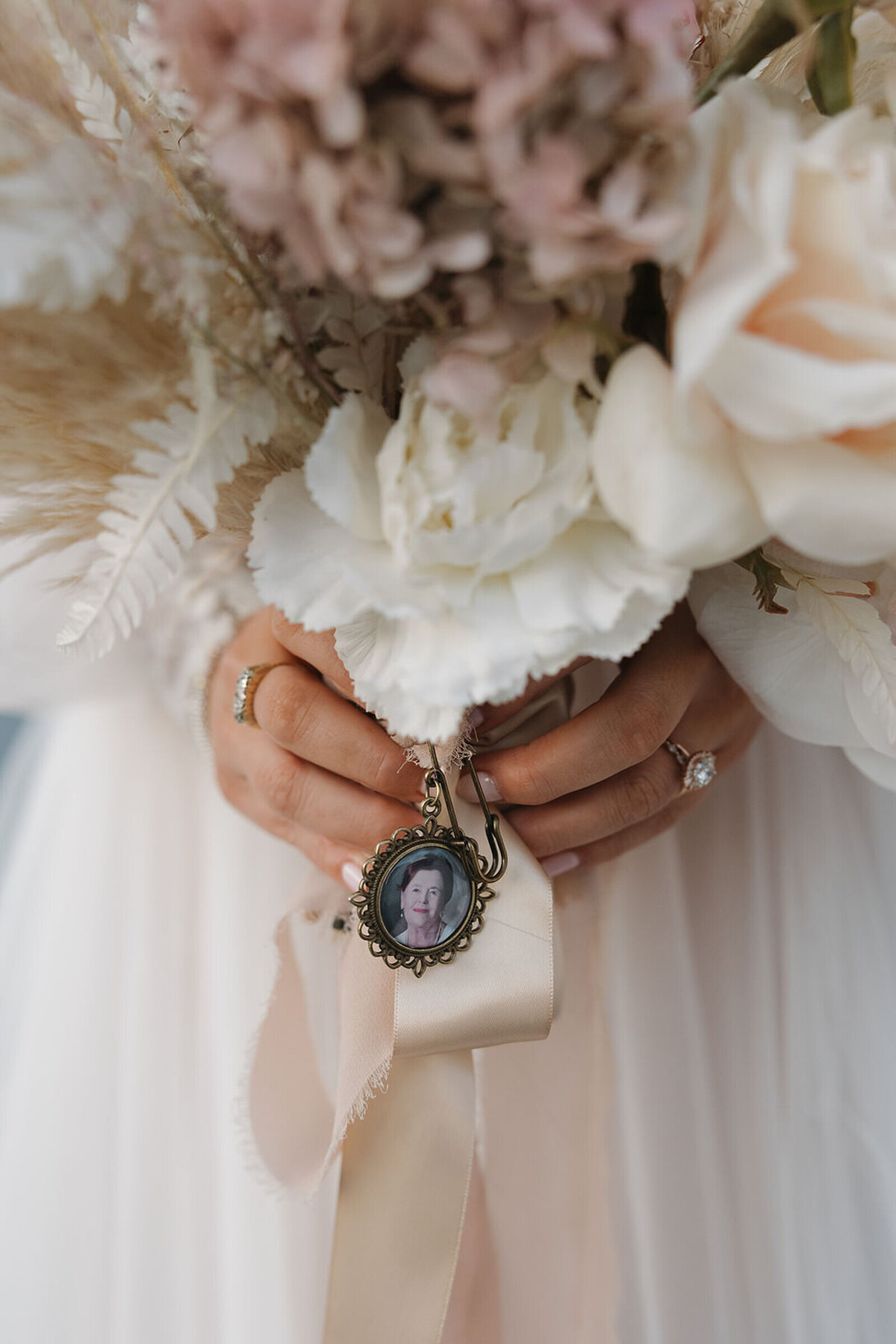 Bride holding her bouquet with a family locket
