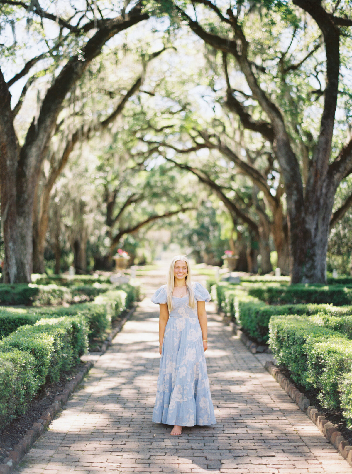 A senior portrait nestled among the florals and southern charm of Rosedown Plantation, captured with timeless elegance on film by Morgan Alysse, Louisiana film photographer.