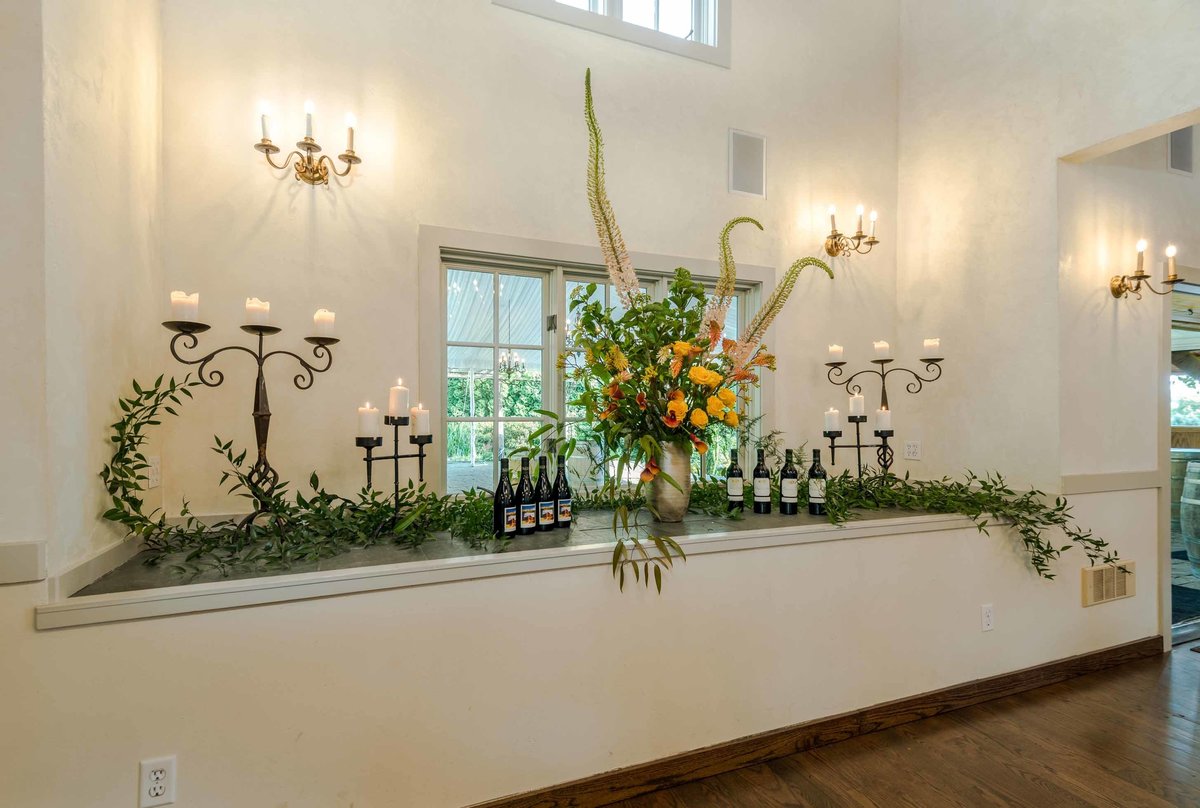 buffet table with greenery and tall flower arrengement and candelabras at Chateau lill