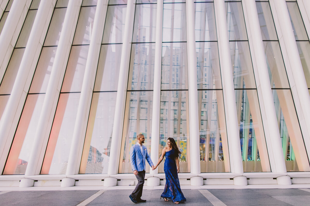 A couple walking past the oculus in nyc during their engagement session