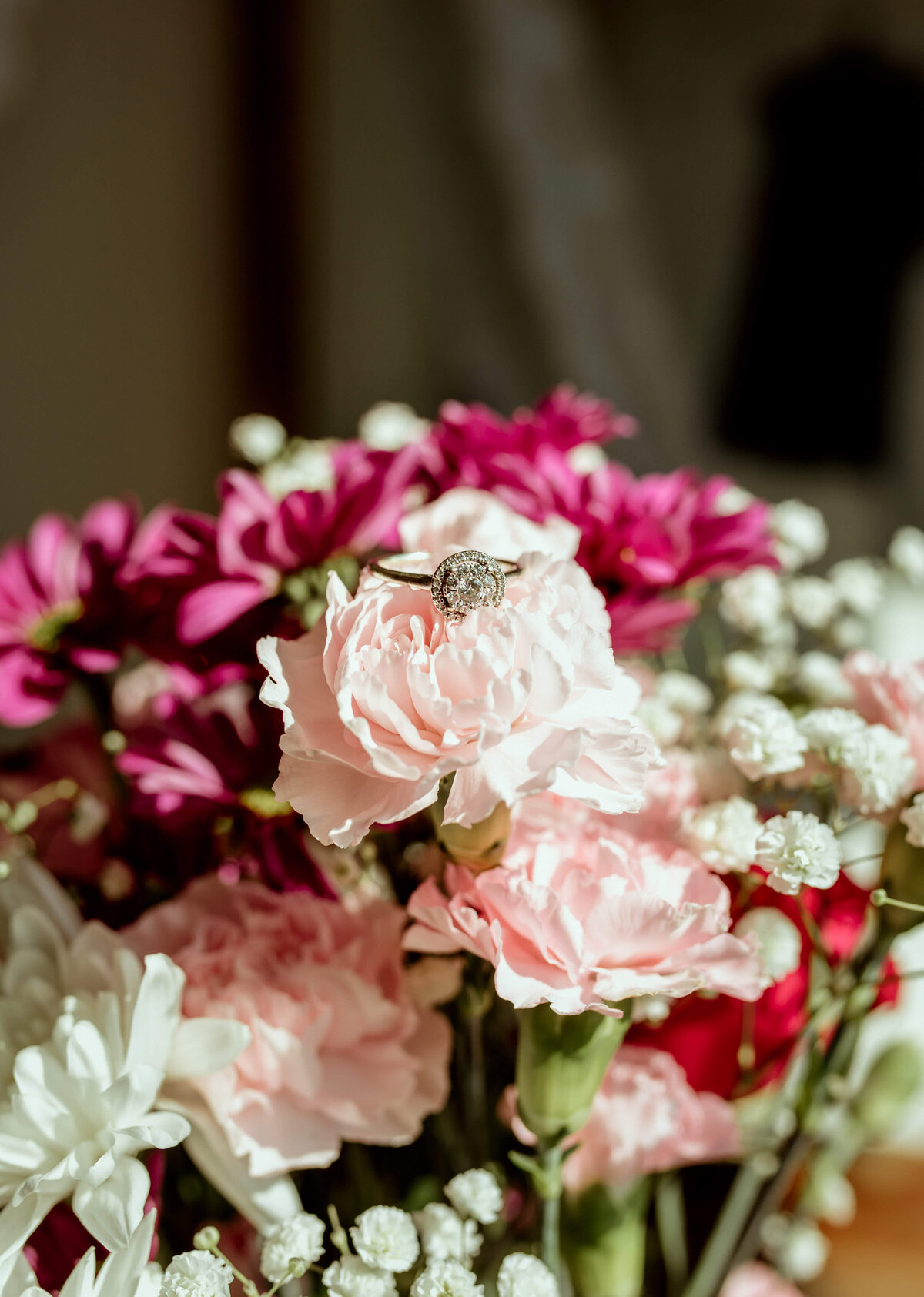 detail shot of wedding ring in floral arrangement for intimate elopement