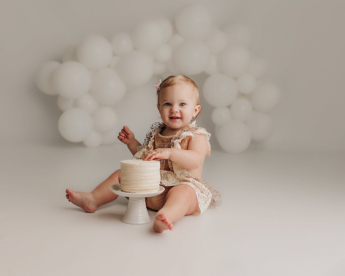 Boho-themed first birthday cake smash photo set with baby and props
