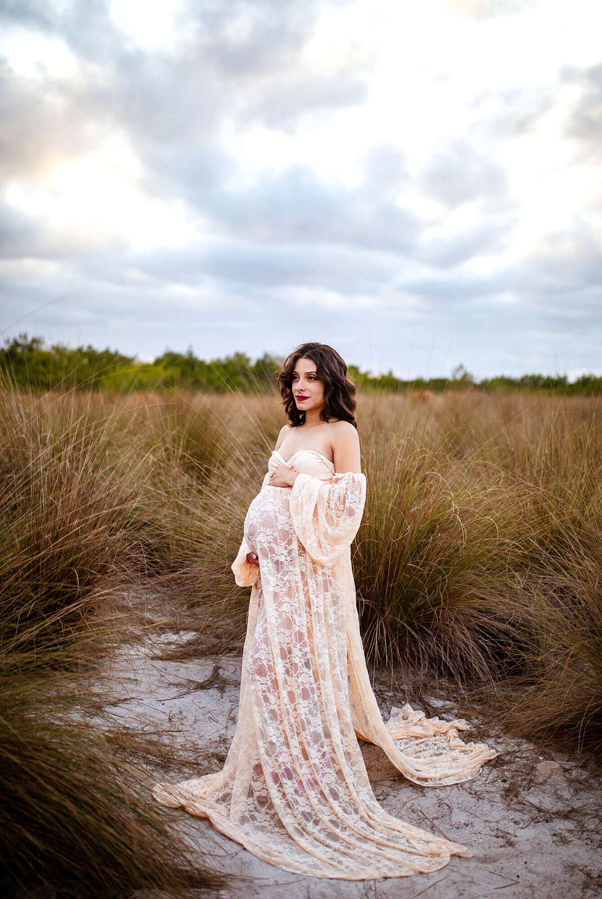 Dark haired pregnant women in lace maternity gown at Cypress Point park 