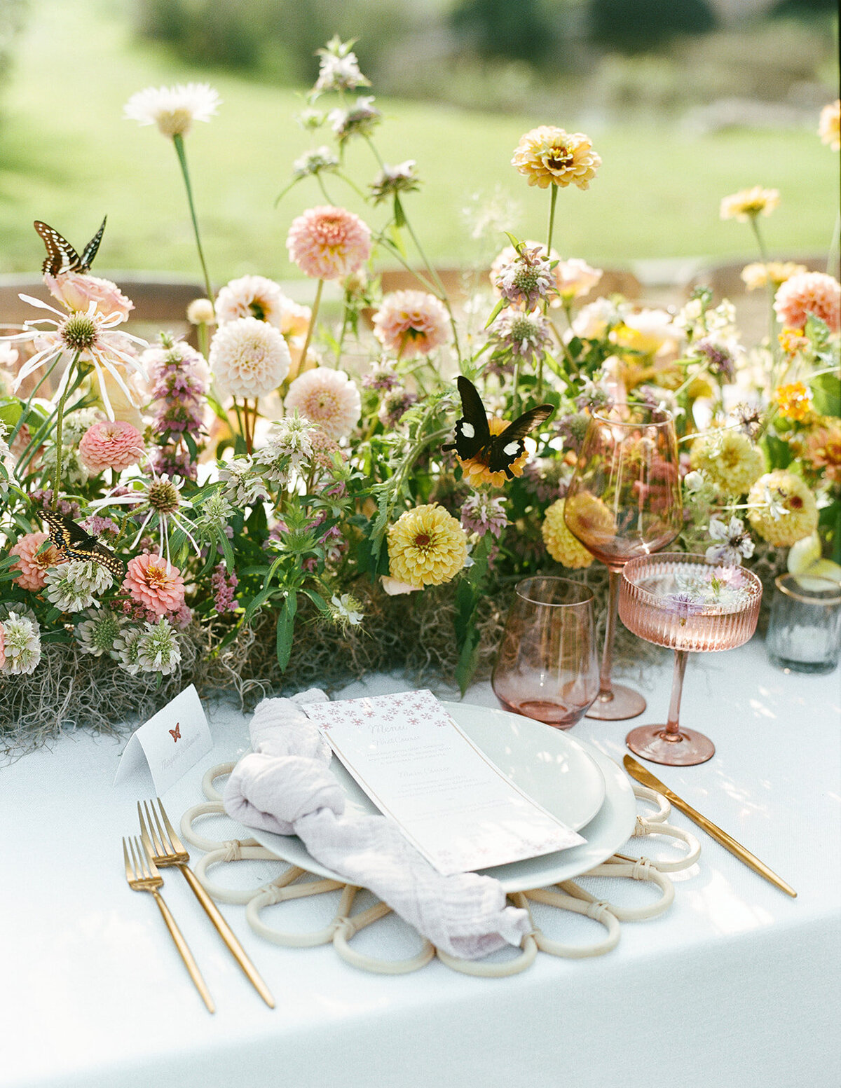 Whimsical colorful pastel garden party wedding reception table with handpainted watercolor butterfly placecard and flower dinner menu by Dear Margo Designs with florals by Rooted Floral Designs