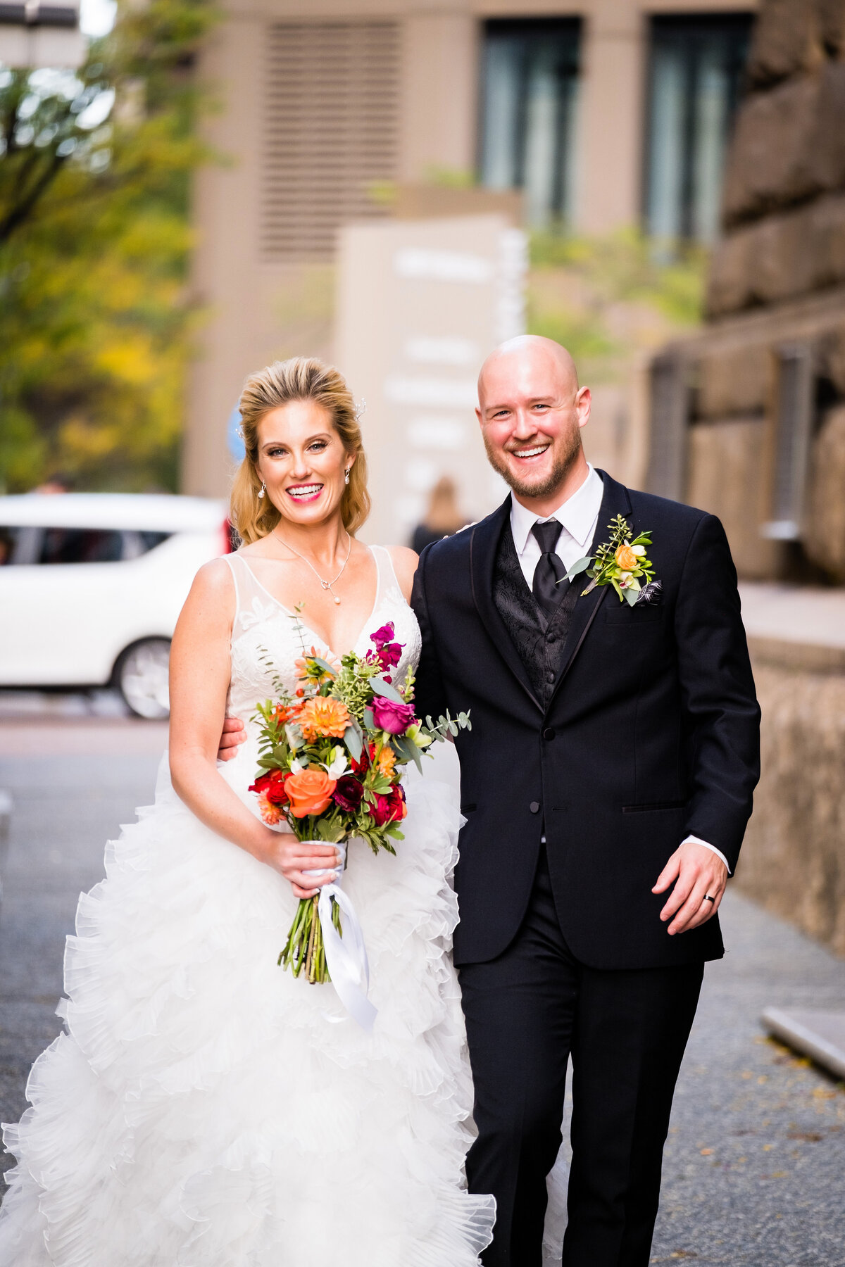 newly married couple walking down pittsburgh city street after their ceremony inside of the allegheny county courthouse