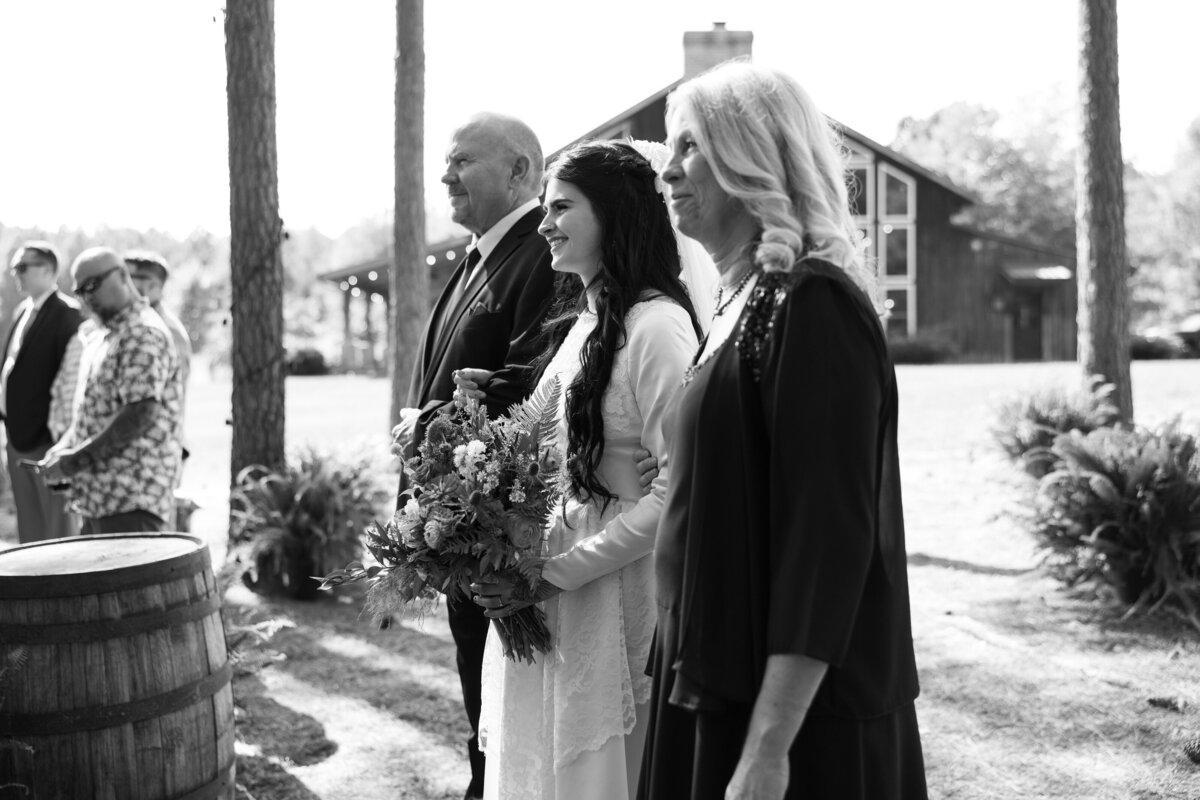 Parents walking their daughter down the aisle during her wedding