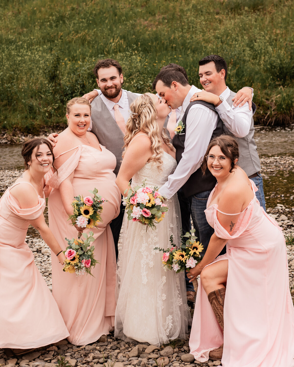 Wedding party surrounds bride and groom and shower them with love