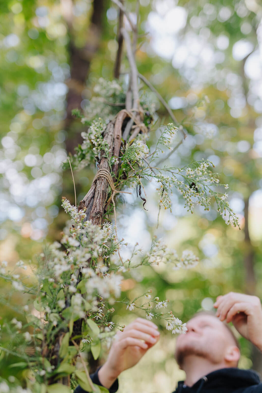 A man smelling tree blossom