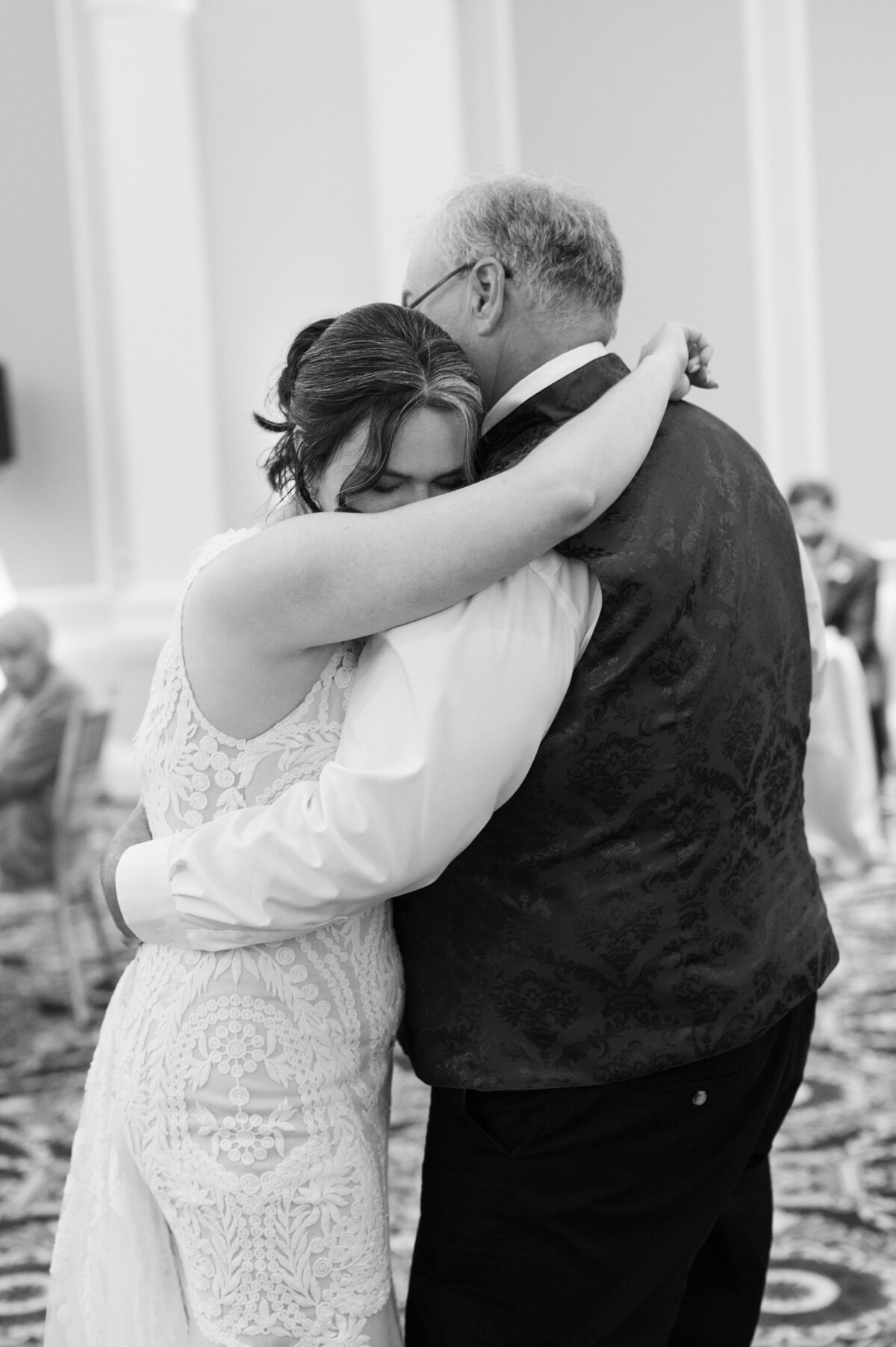 A bride dancing with an older man at her wedding reception