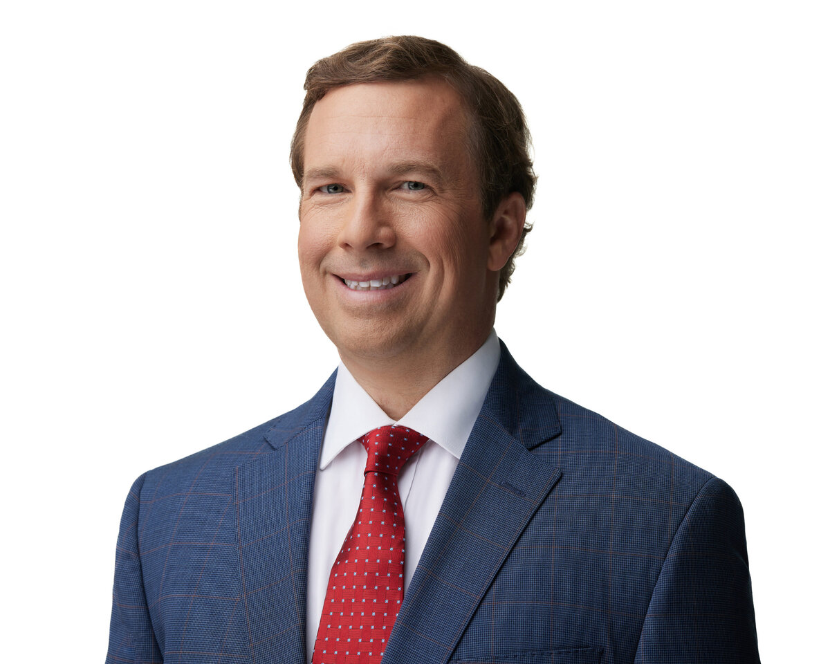 A man in a suit smiling big