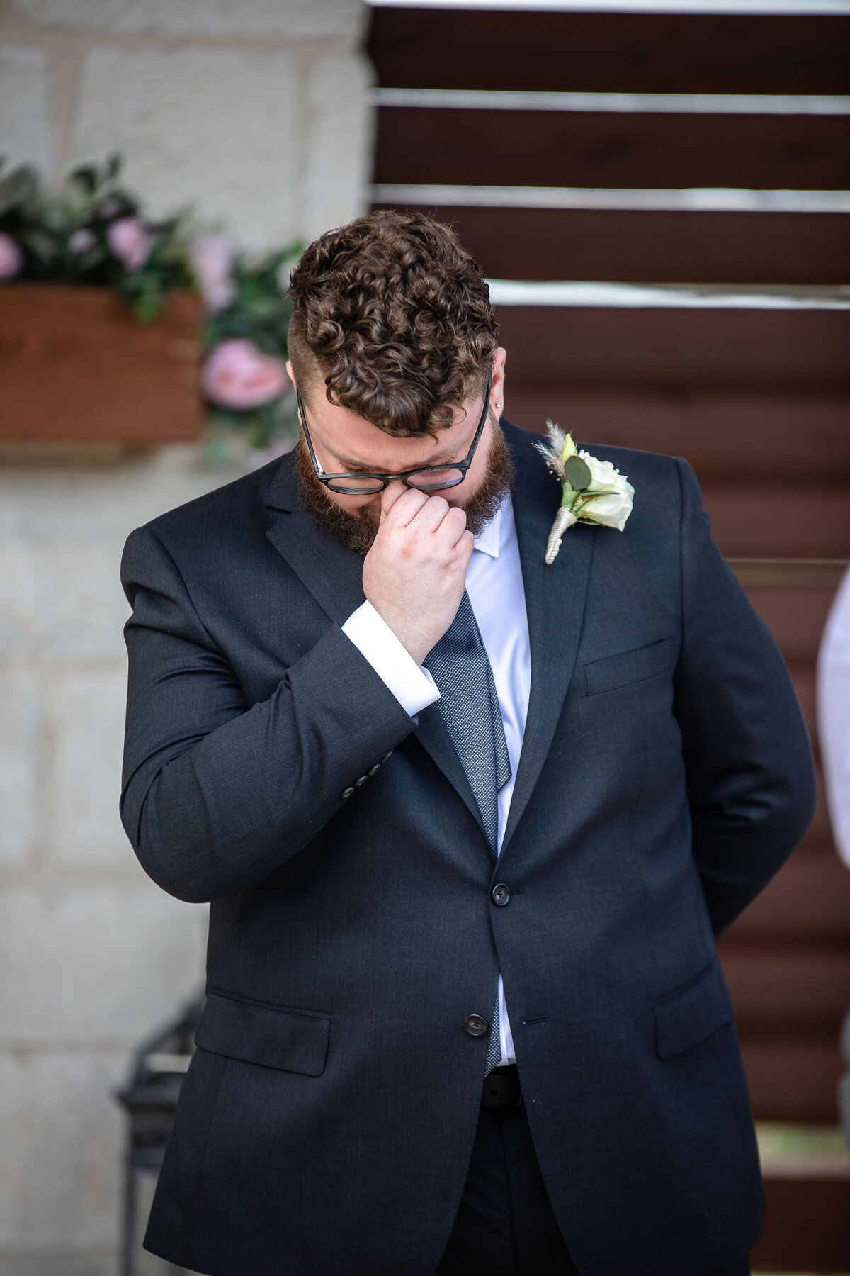 groom holds bridge of his nose to stop crying  while bride walks down aisle at Milestone New Braunfels wedding