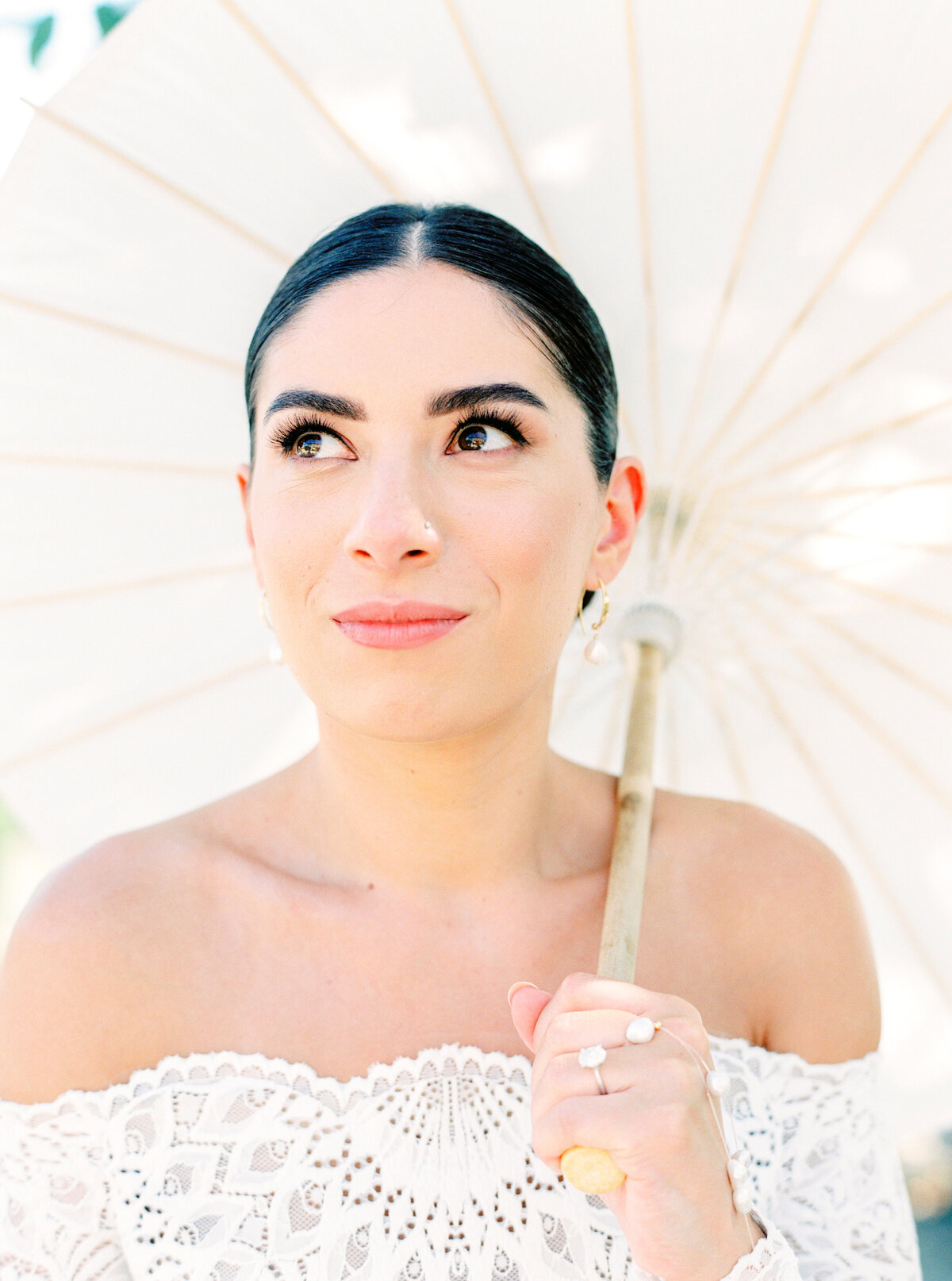 Film photograph of bride in all lace off the shoulder wedding dress with long sleeves holding a parasol photographed by Italy wedding photographer at Villa Montanare Tuscany wedding