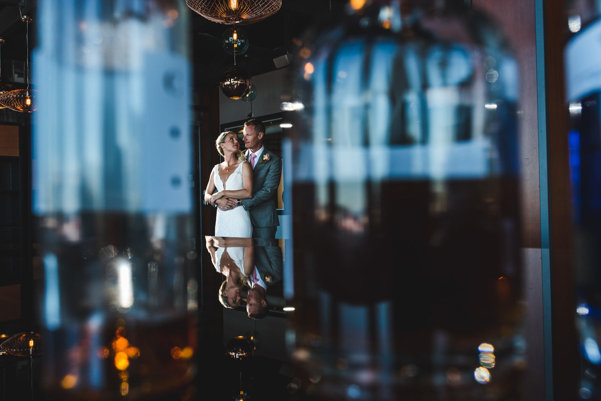 Couple standing between bottles on their wedding day