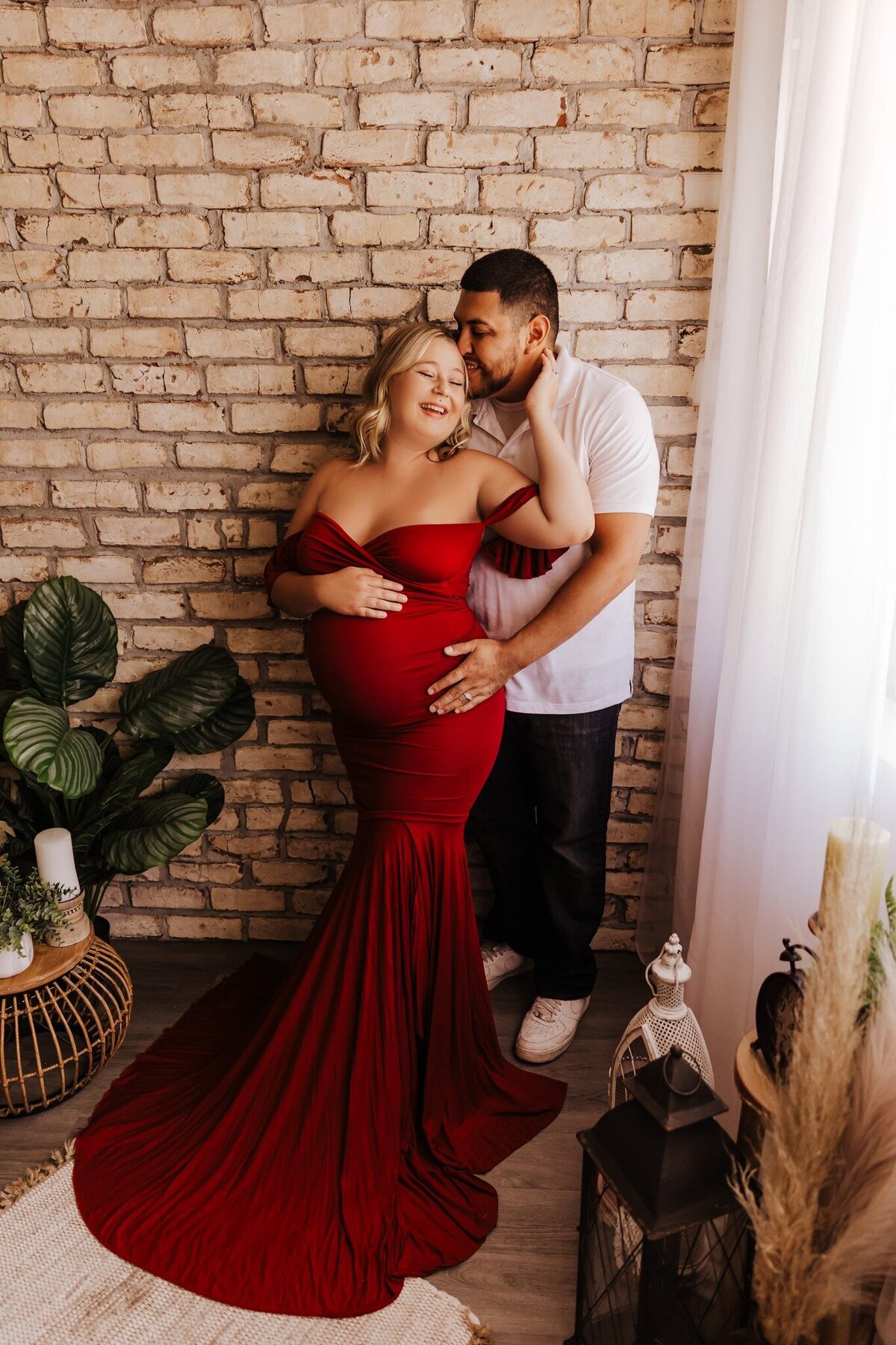 woman in red dress with husband for studio phoenix maternity session