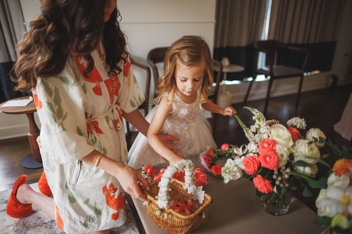 Flower girl putting flower petals on the basket