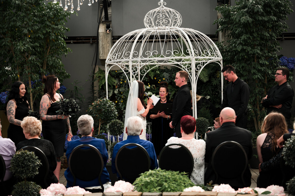 bride and groom in the middle of wedding ceremony at the Muttart Conservatory in Edmonton, Alberta