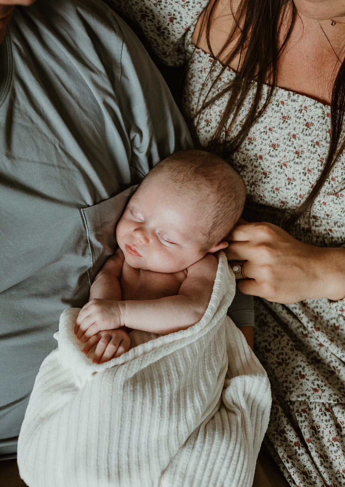 Newborn held by parents