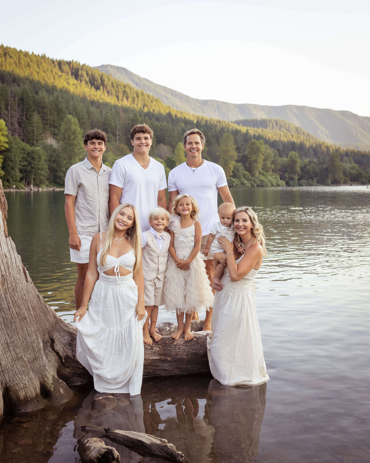 Family snuggling on a log in the water in Seattle