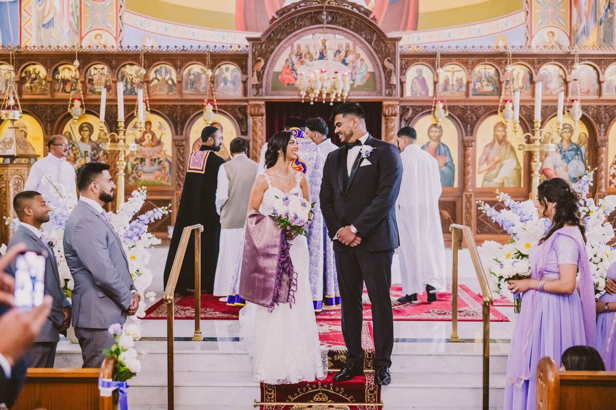 indian christian malayali bride and groom smiling at each other after the ceremony inside the zoodohos peghe orthodox church