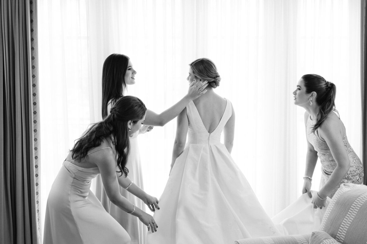 A bride gets ready with the help of her bridesmaids, exuding grace and elegance, captured by Rodrigo Varela Photography.