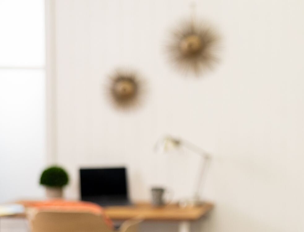 Blurred laptop on a table with a small plant in the background, used to promote Get Hired Lab’s Free Resume Review offer.