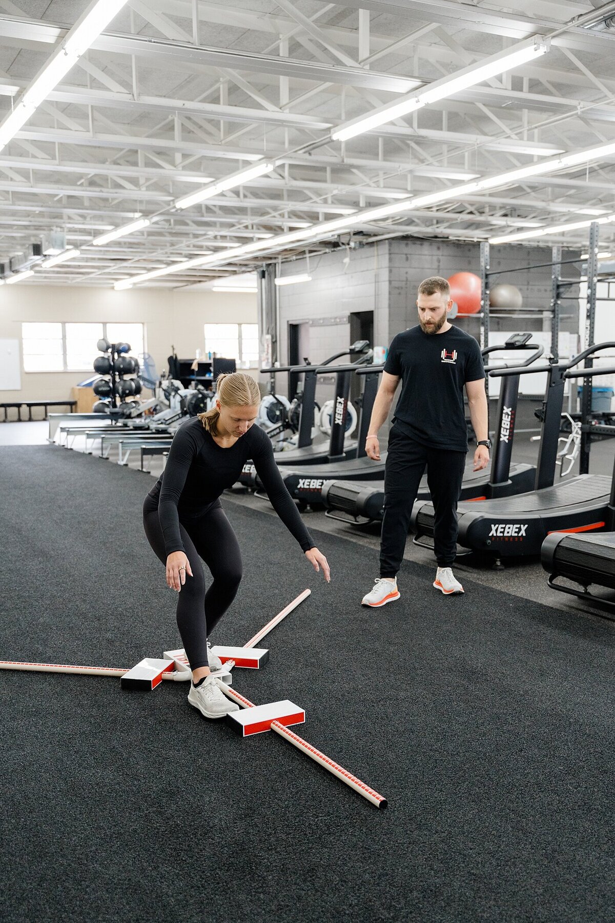personal trainer photographed by Columbus brand photographer with a trainer helping a woman train on balance in the gym