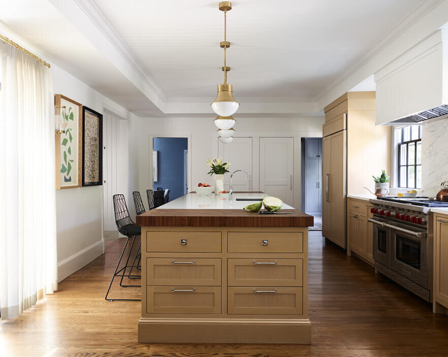 Oak cabinets with walnut butcher block counters in a historic home renovation project by Hingham interior designers, blending classic and contemporary styles seamlessly.