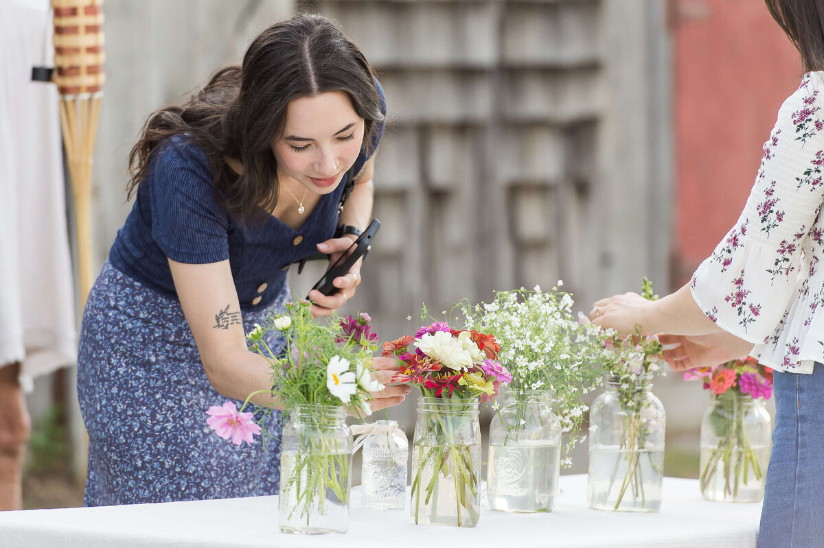Ottawa event photography showing a woman selecting florals to add to her DIY table centerpiece at Soiree in the Field.  Captured by JEMMAN Photography COMMERCIAL