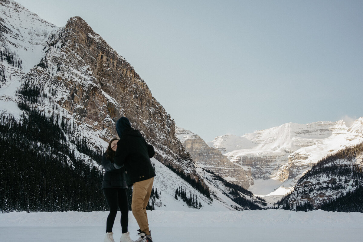 couple holding hands by snowy mountain